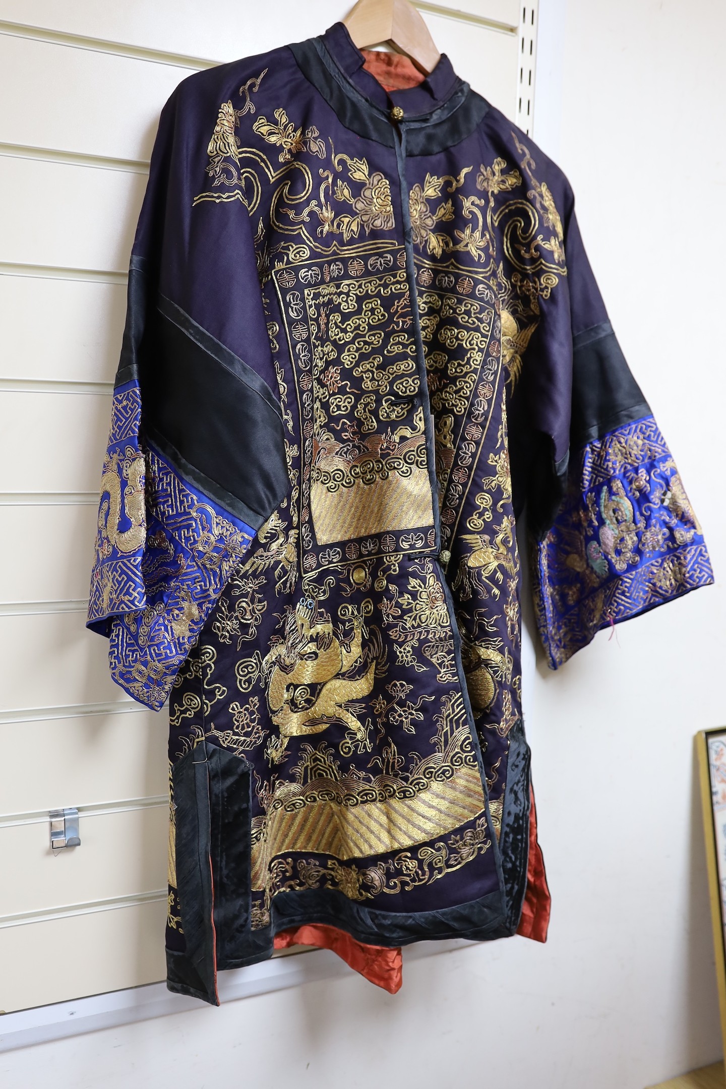 A 20th century Chinese robe, decorated with navy ground and gilt thread all over five claw dragons